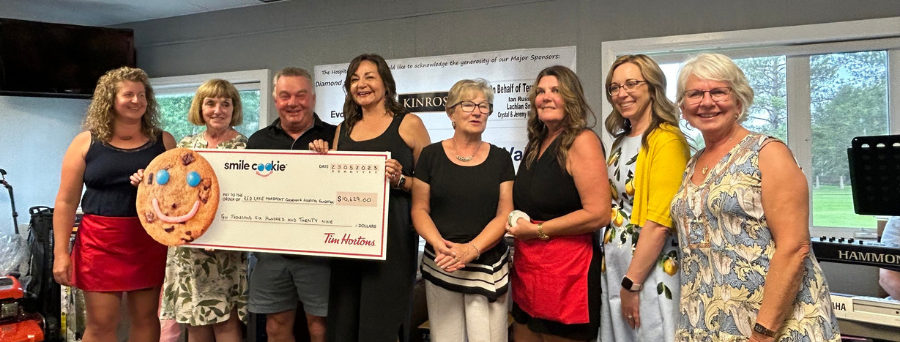 Staff holding a smile-cookie cheque